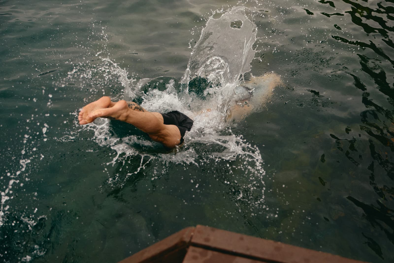 Swimmer diving into dark open water