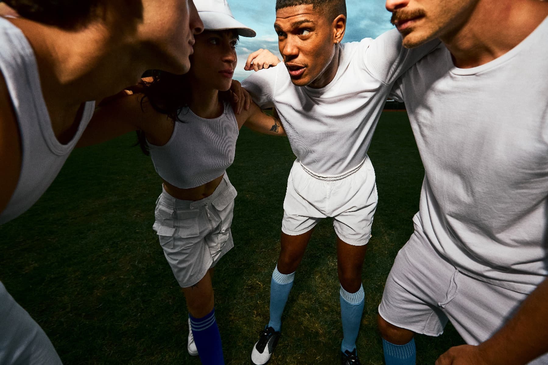 Athletes gathered closely on a grass field